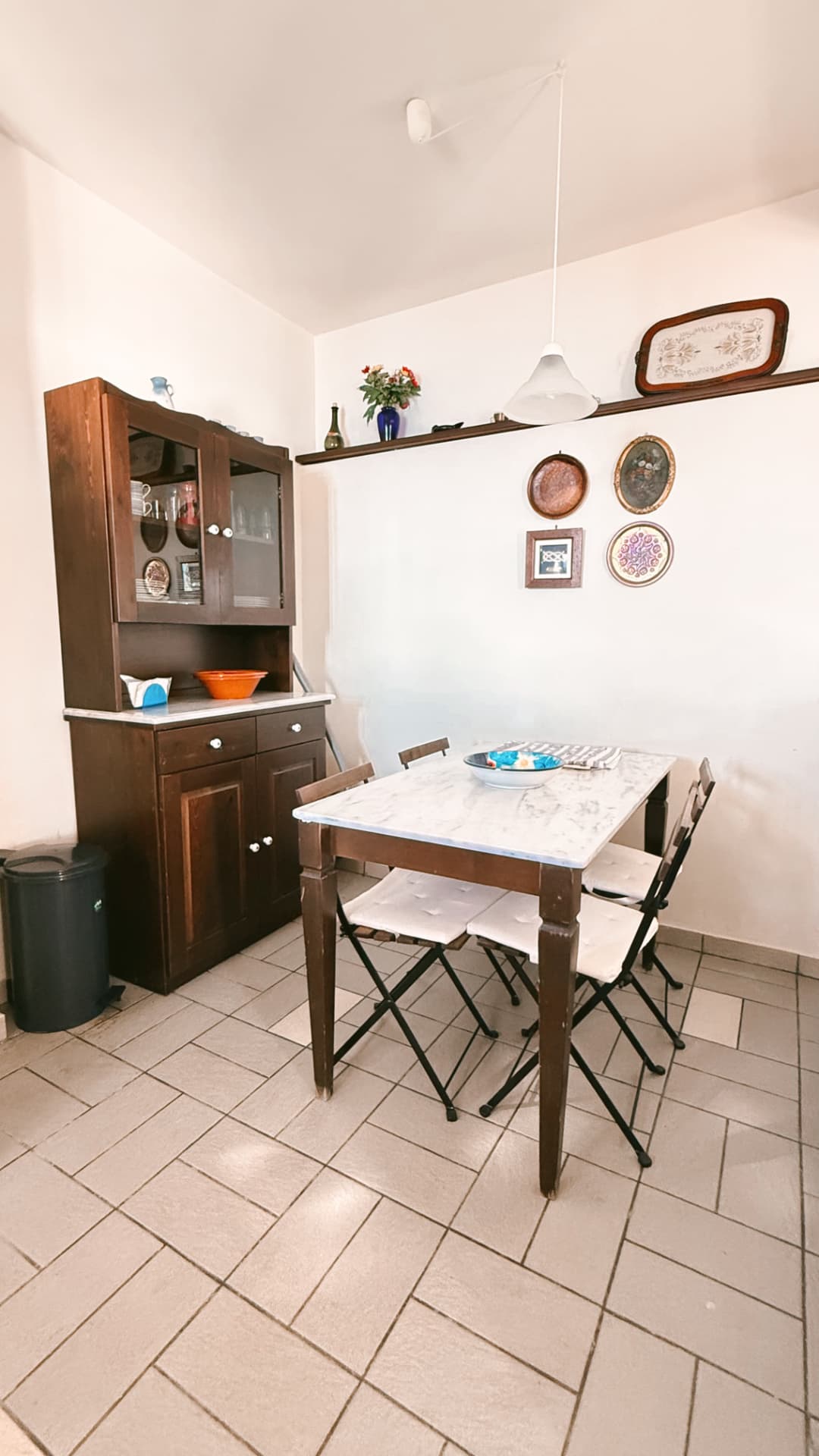 Ground-floor dining area with a marble-topped table and decorative wall plates