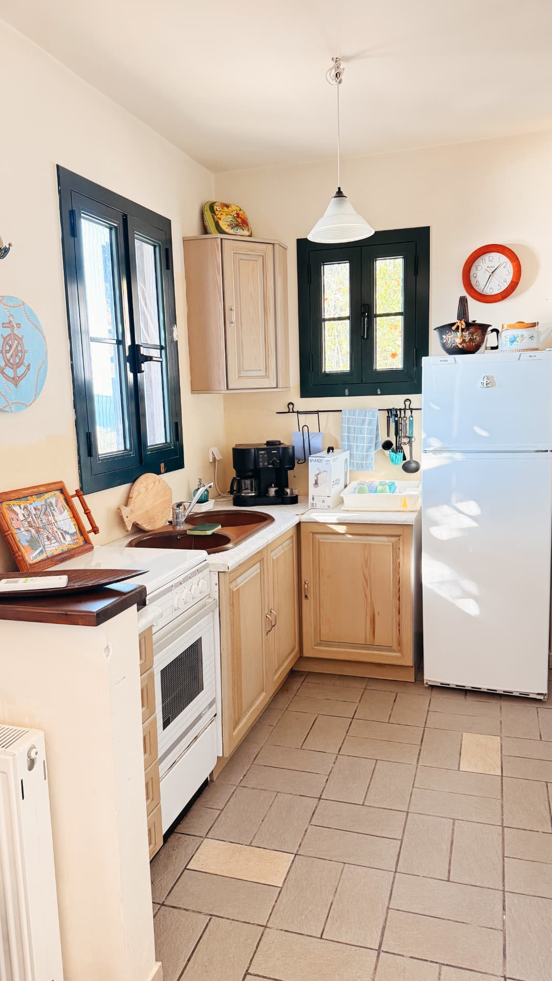 Ground-floor kitchen with light wood cabinets and dark-framed windows