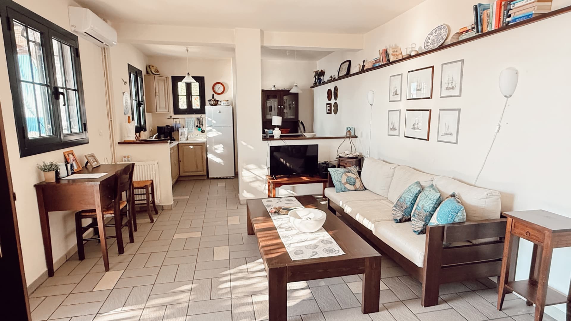 Ground-floor living, kitchen and dining room with cream sofas and sea-facing windows