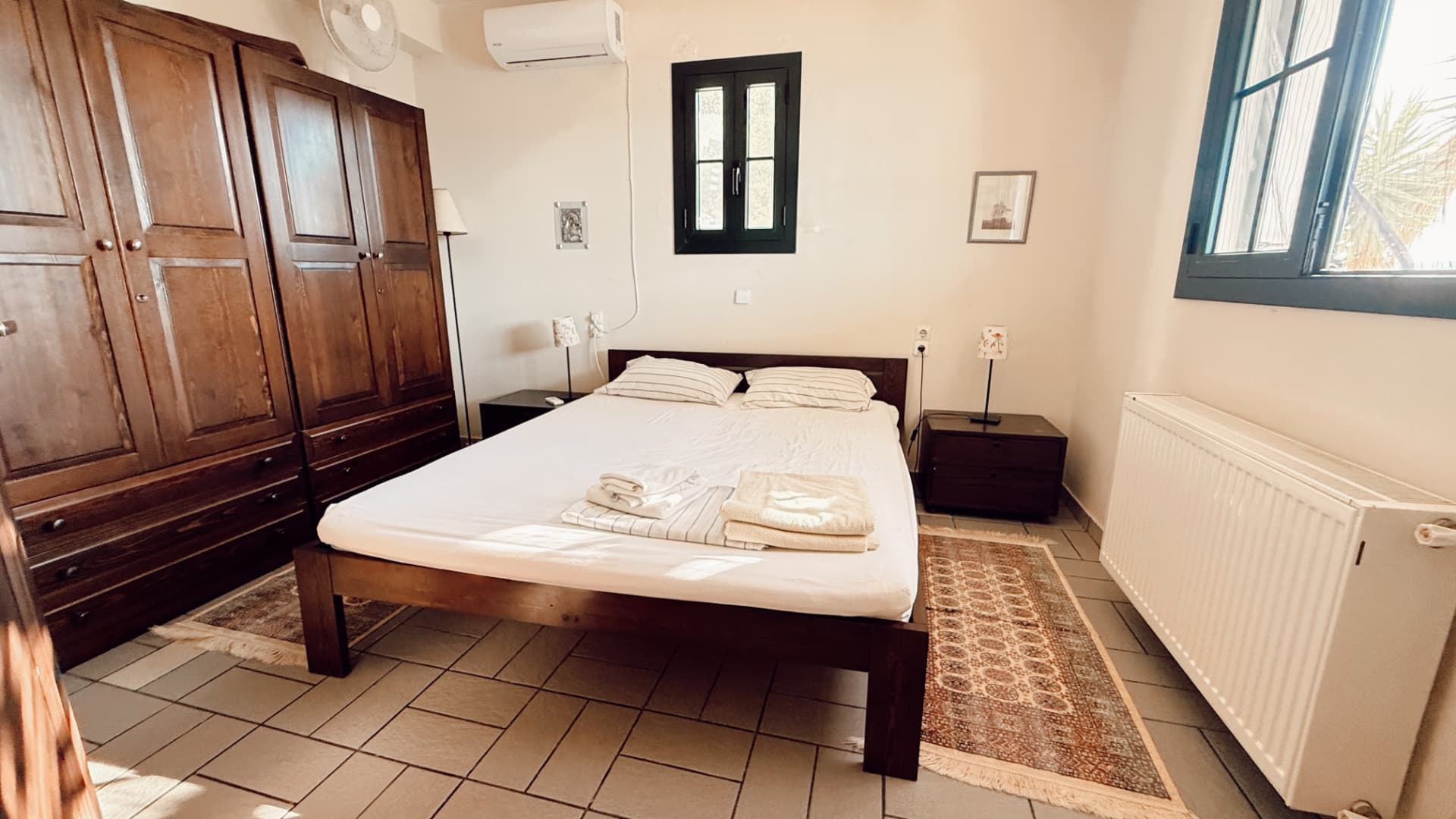 Ground-floor master bedroom with double bed and dark wood wardrobes